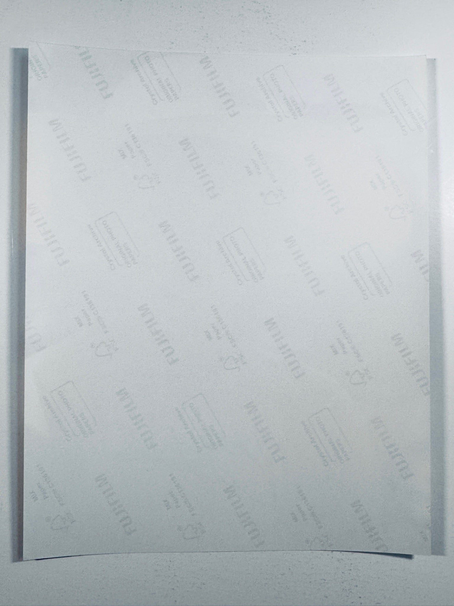The plain white reverse side representing the back physical condition of the photograph print, showing translucent Fujifilm crystal archive paper watermarks and logos.