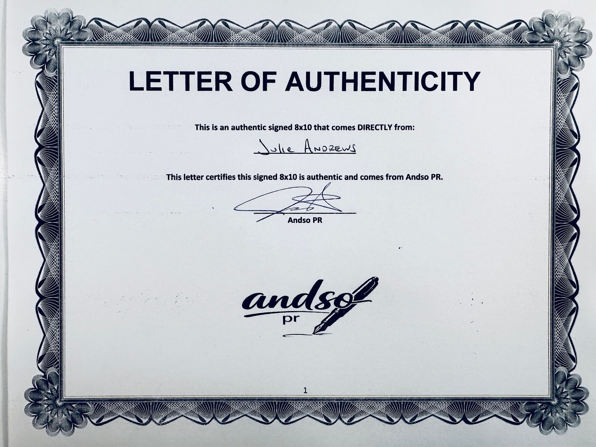 A Letter of Authenticity with a decorative blue-patterned border, certifying an authentic signed 8x10 coming directly from Julie Andrews, featuring a signature at the top.