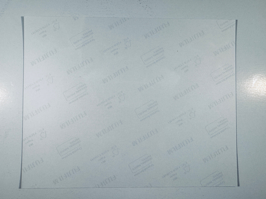The plain white reverse side of a photographic print showing translucent Fujifilm crystal archive paper watermarks and logos.