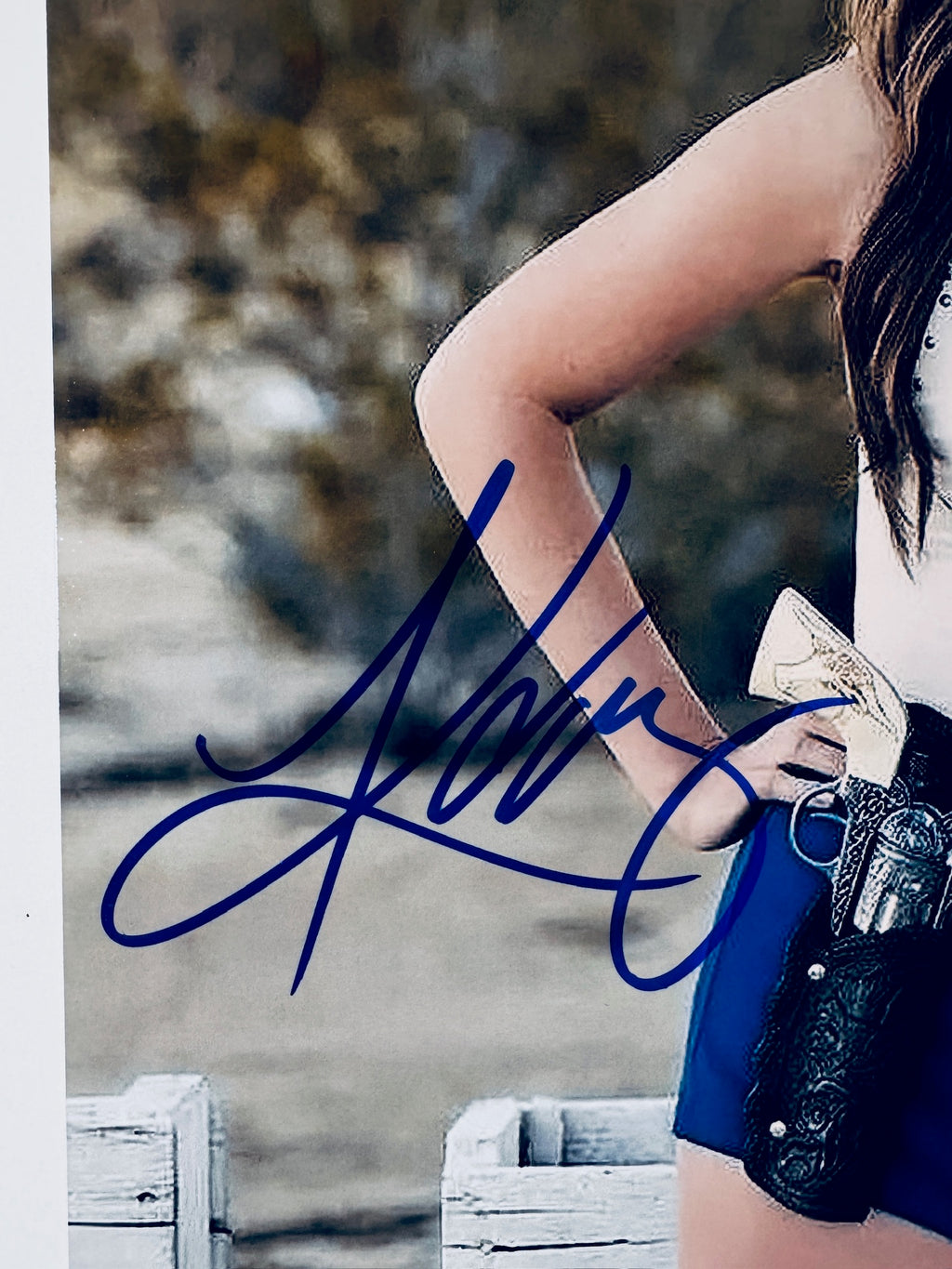 Close-up of Kacey Musgraves's signature in blue marker on the signed country music star 8x10 photo.
