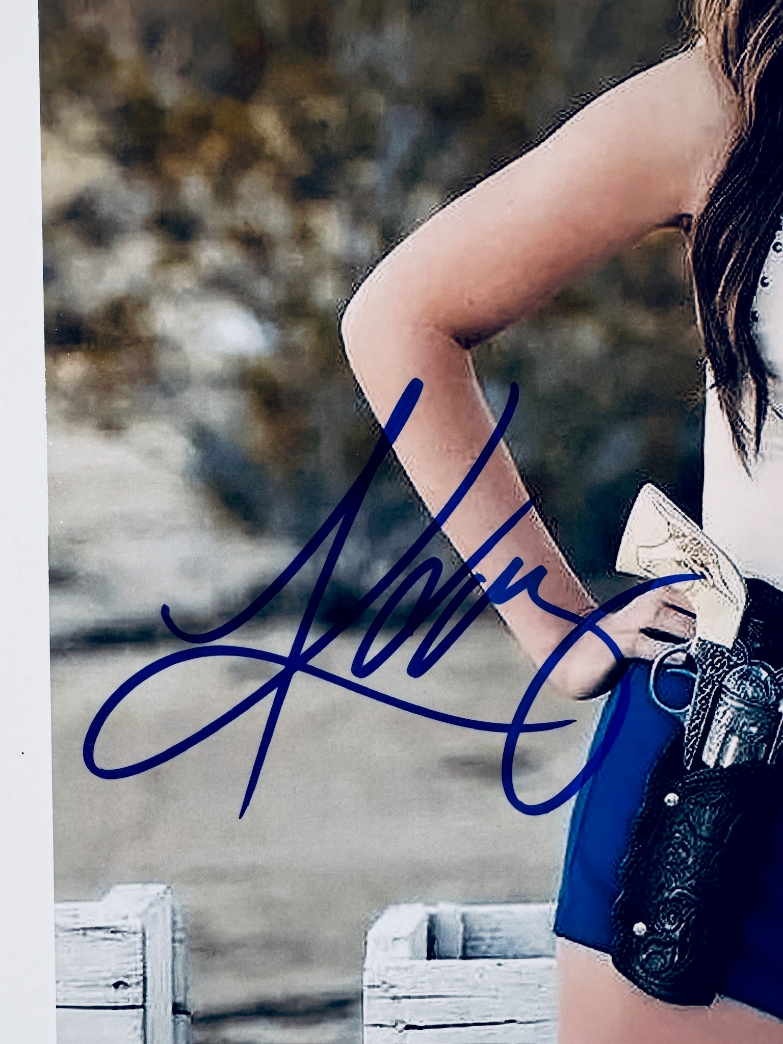 Close-up of Kacey Musgraves's signature in blue marker on the signed country music star 8x10 photo.