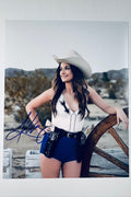 Kacey Musgraves hand-signed 8x10 matte photo wearing a cowboy hat and cowgirl outfit with holsters outdoors.