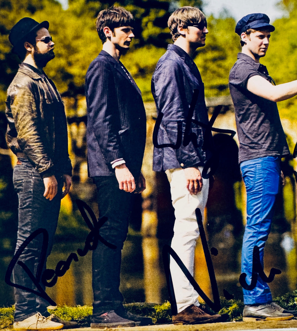 Close-up view of signatures from Peanut, Nick Hodgson, and Andrew White on Kaiser Chiefs photo postcard.