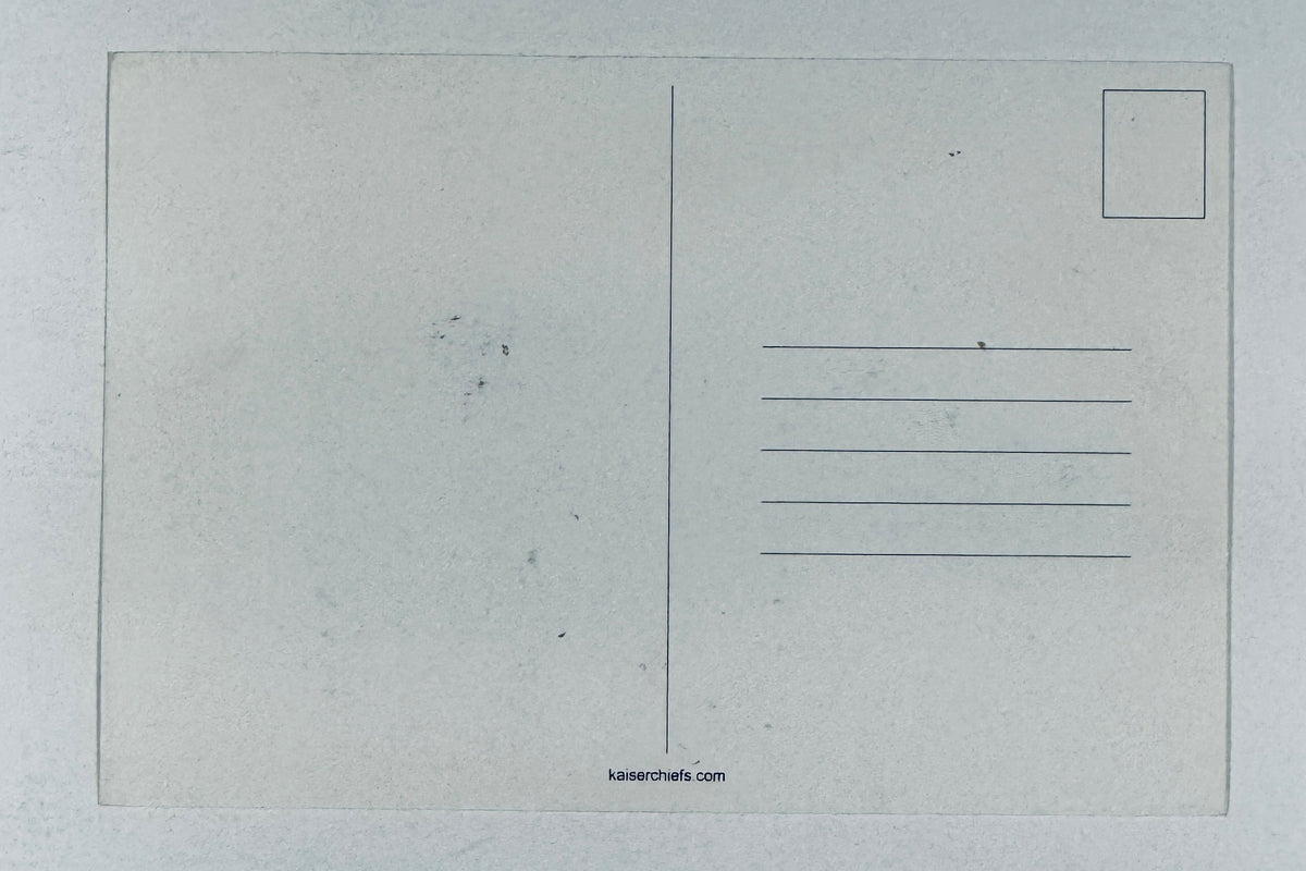 Full back view of blank, unposted Kaiser Chiefs promotional postcard showing address lines and website URL.