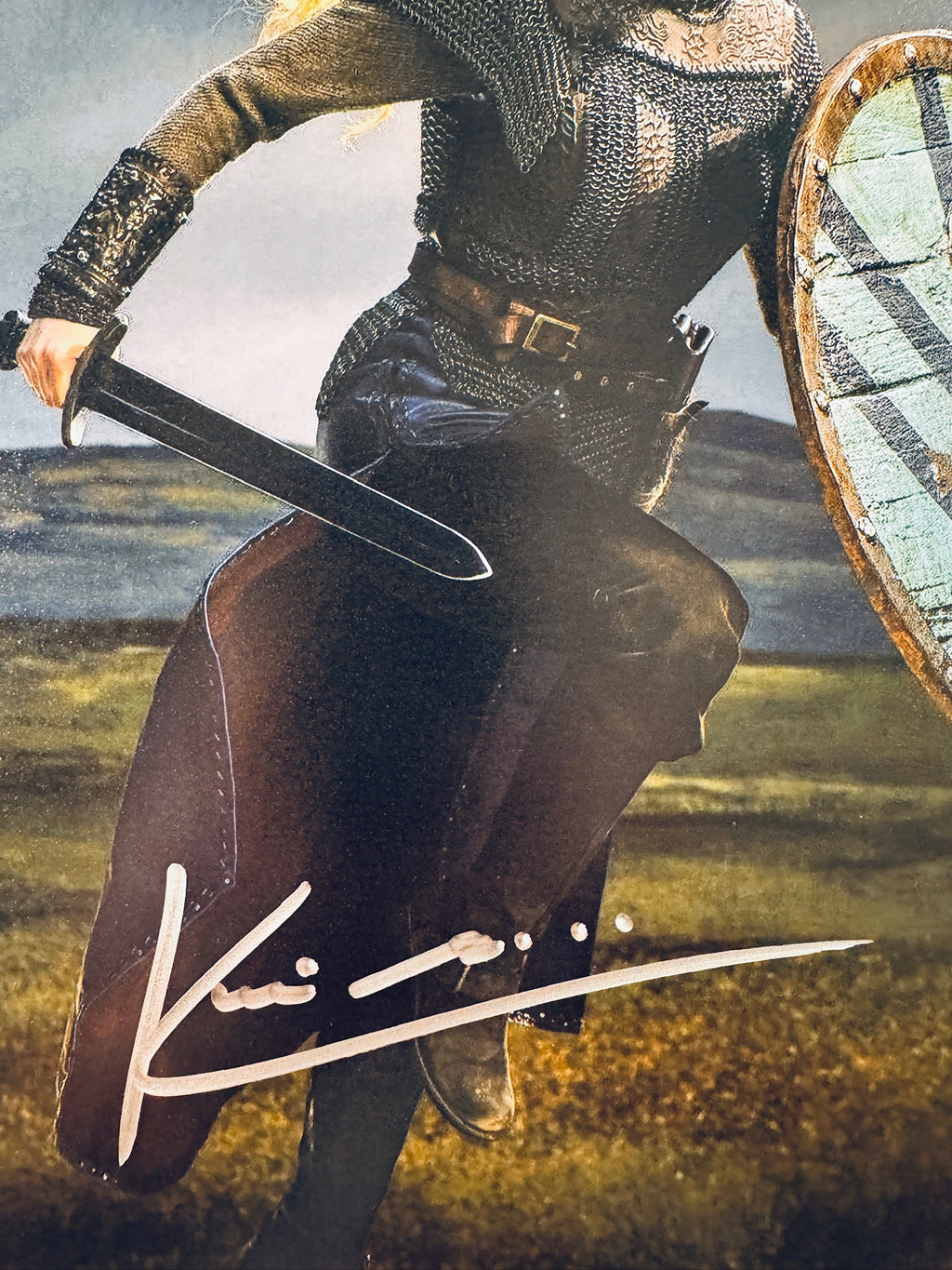 Close-up view of Katheryn Winnick's signature in silver marker across the Vikings promotional matte photo.
