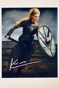 Signed 8x10 matte photo of actress Katheryn Winnick as Lagertha from Vikings running into battle with a sword and shield, featuring a bold silver ink autograph.