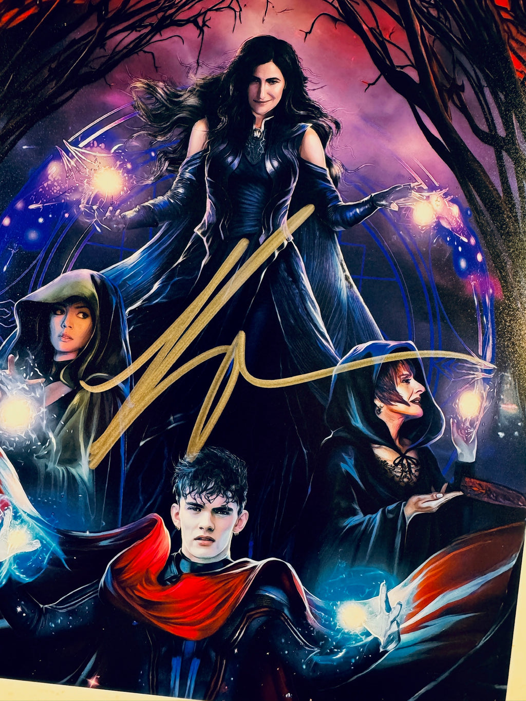 Close-up view of Kathryn Hahn's gold signature across the central characters on the Agatha All Along promotional photograph.