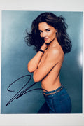 Signed full photo of Katie Holmes posing in denim jeans against a blue background, featuring a black autograph.