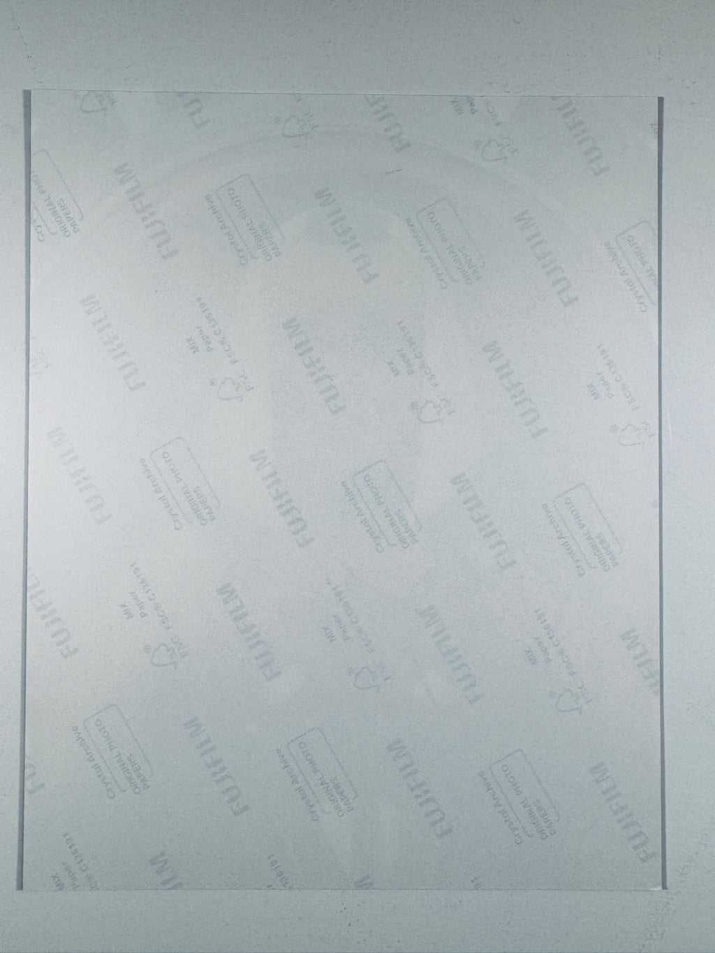 The plain white reverse side of a photographic print showing translucent Fujifilm crystal archive paper watermarks and logos.