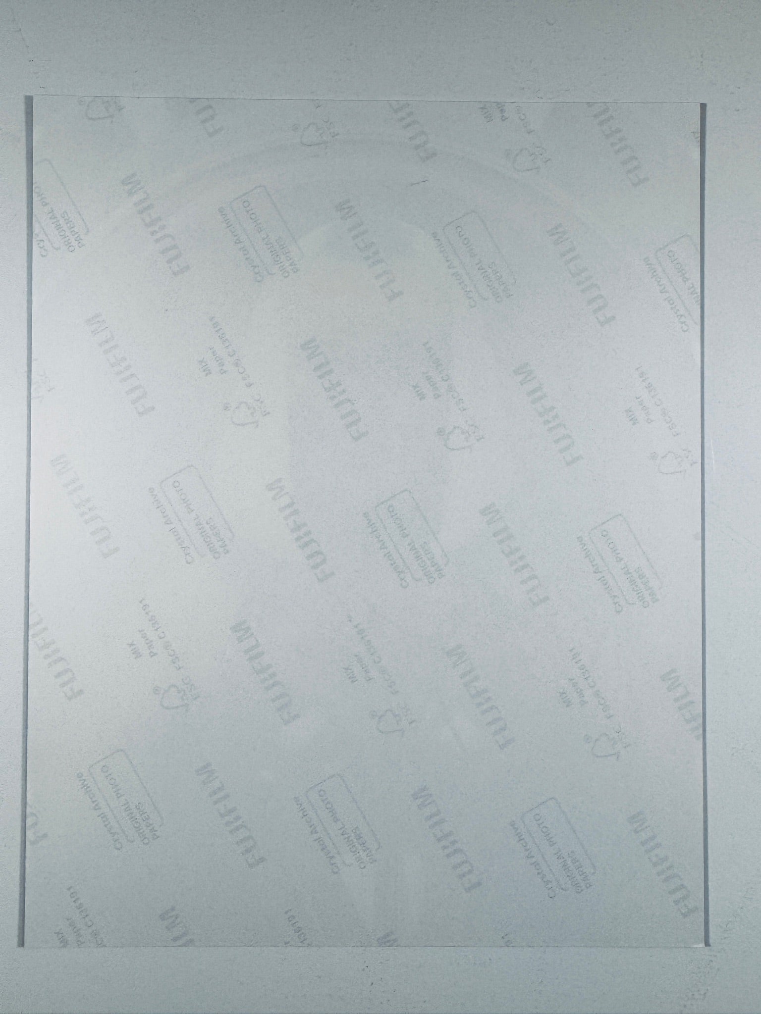 The plain white reverse side of a photographic print showing translucent Fujifilm crystal archive paper watermarks and logos.