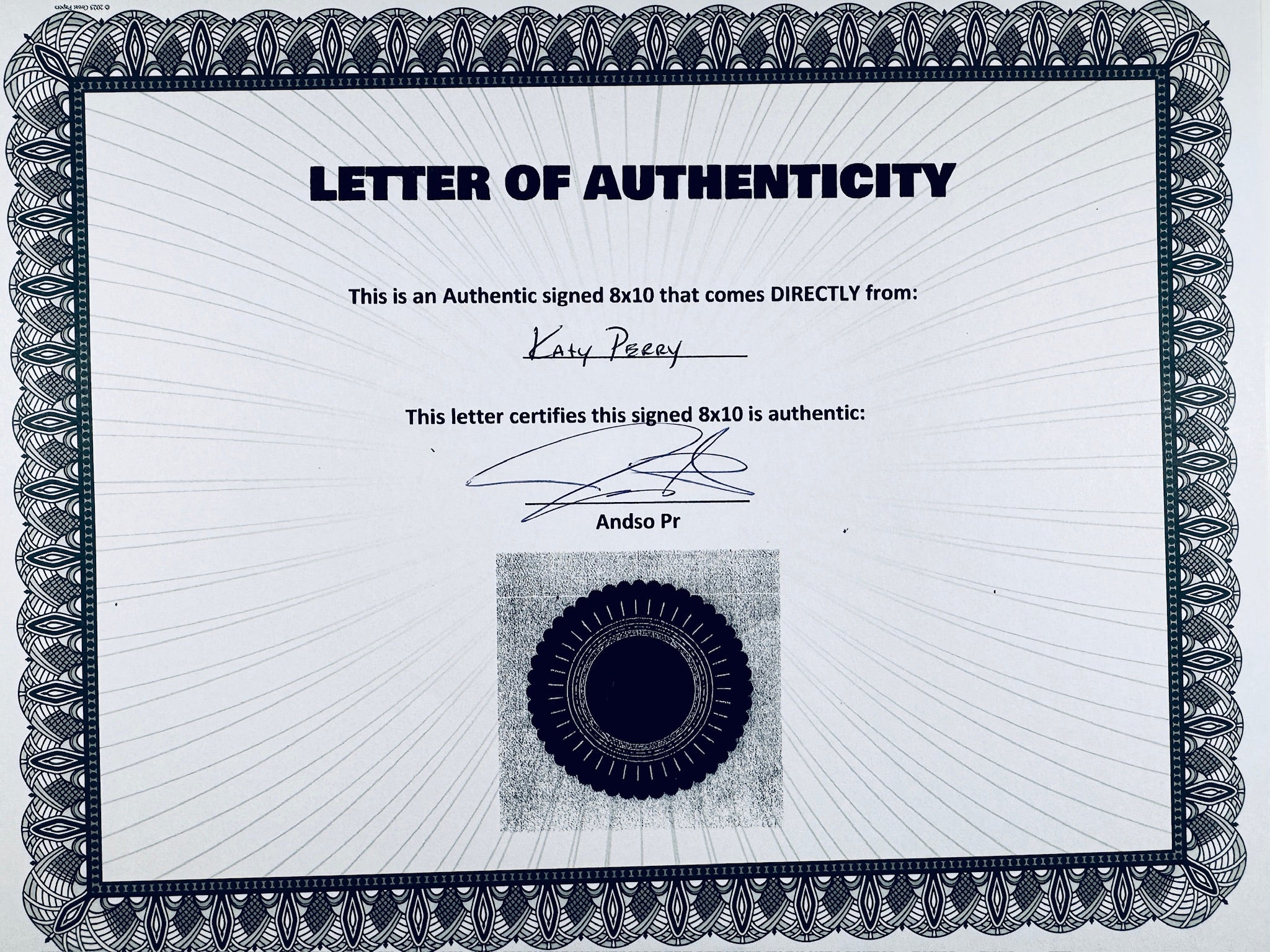 A Letter of Authenticity with a decorative blue-patterned border, certifying an authentic signed 8x10 coming directly from Katy Perry, featuring a dark circular seal graphic at the bottom.