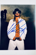 Signed 8x10 matte photo of Kid Rock wearing a hat, sunglasses, and an unzipped white jacket, featuring a bold blue ink autograph.
