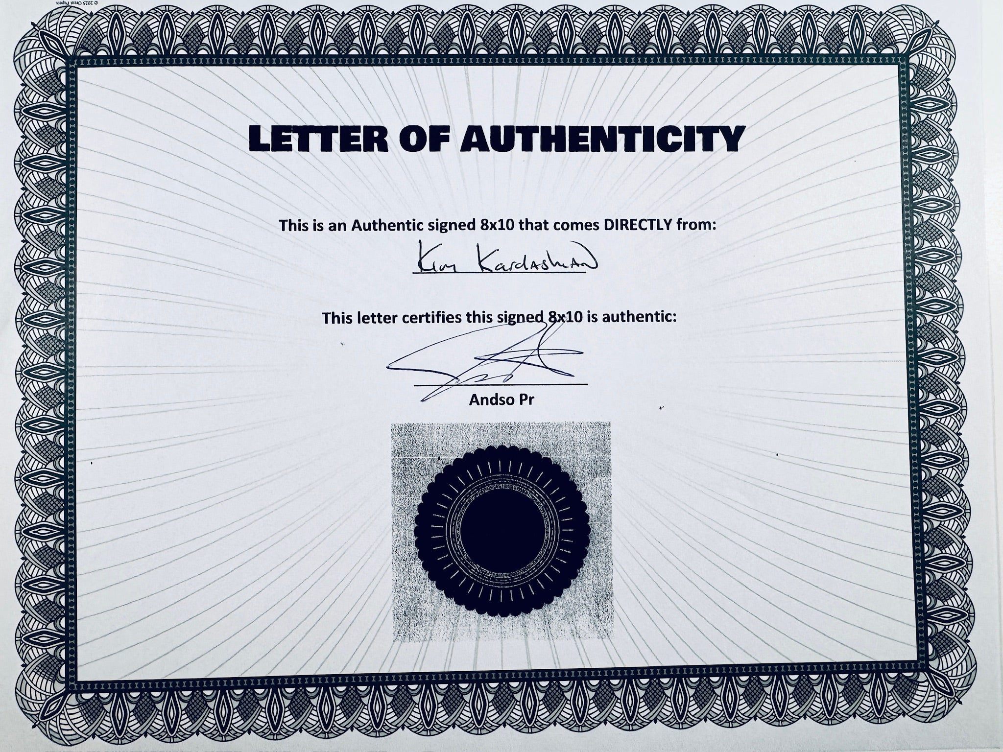 A Letter of Authenticity with a decorative blue-patterned border, certifying an authentic signed 8x10 coming directly from Kim Kardashian, featuring a dark circular seal graphic at the bottom.
