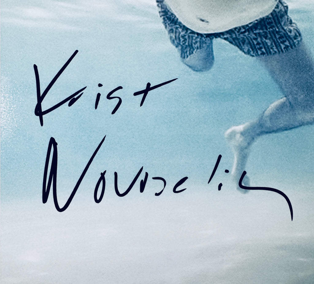 Close-up of Krist Novoselic's signature in black marker on the signed Nirvana 8x10 photo.