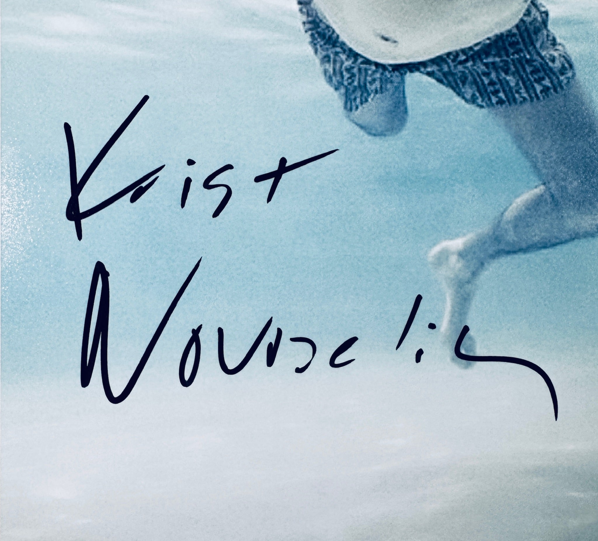 Close-up of Krist Novoselic's signature in black marker on the signed Nirvana 8x10 photo.