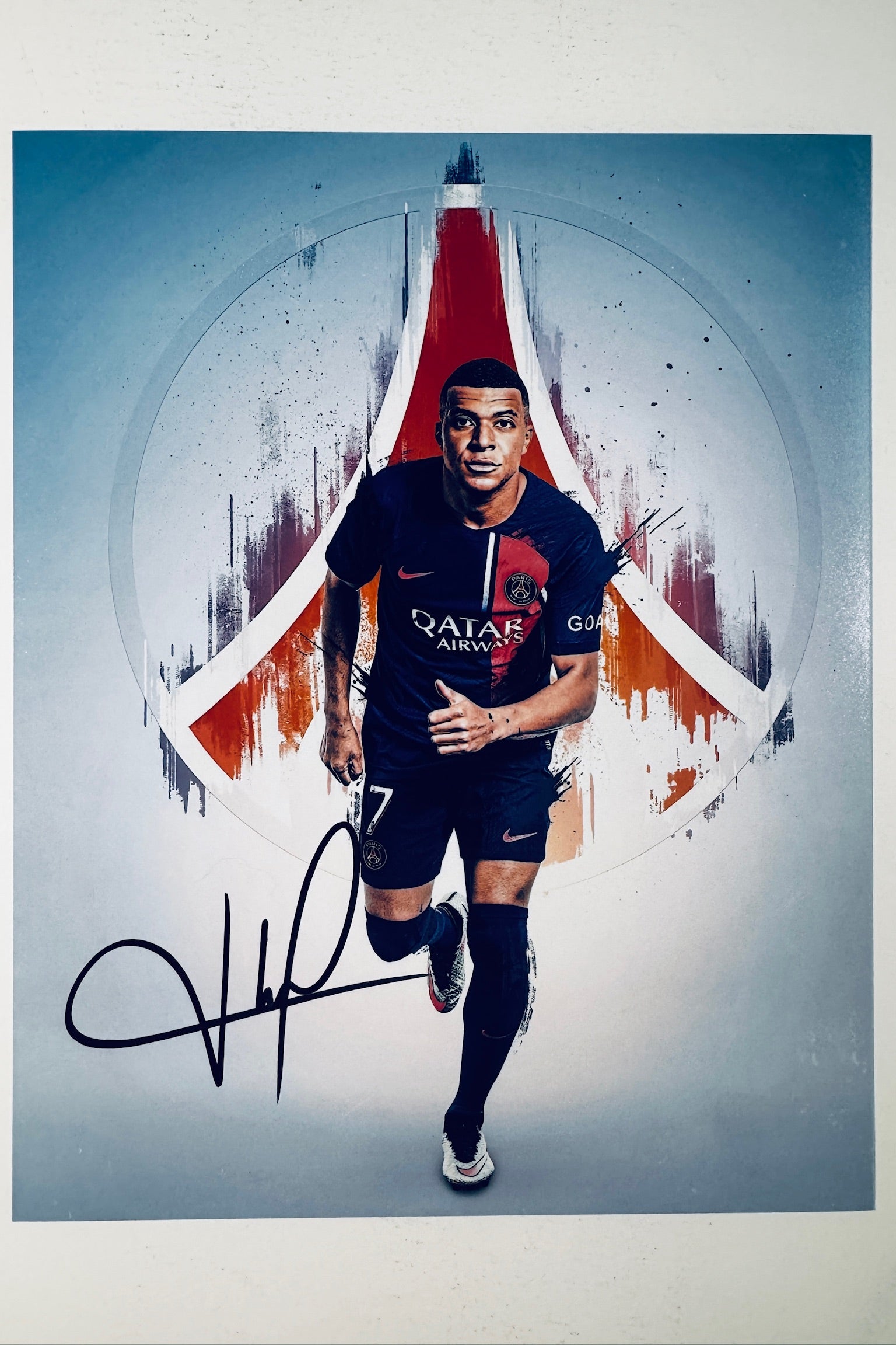 Kylian Mbappe hand-signed 8x10 matte photo running in a Paris Saint-Germain kit against an abstract architectural background.