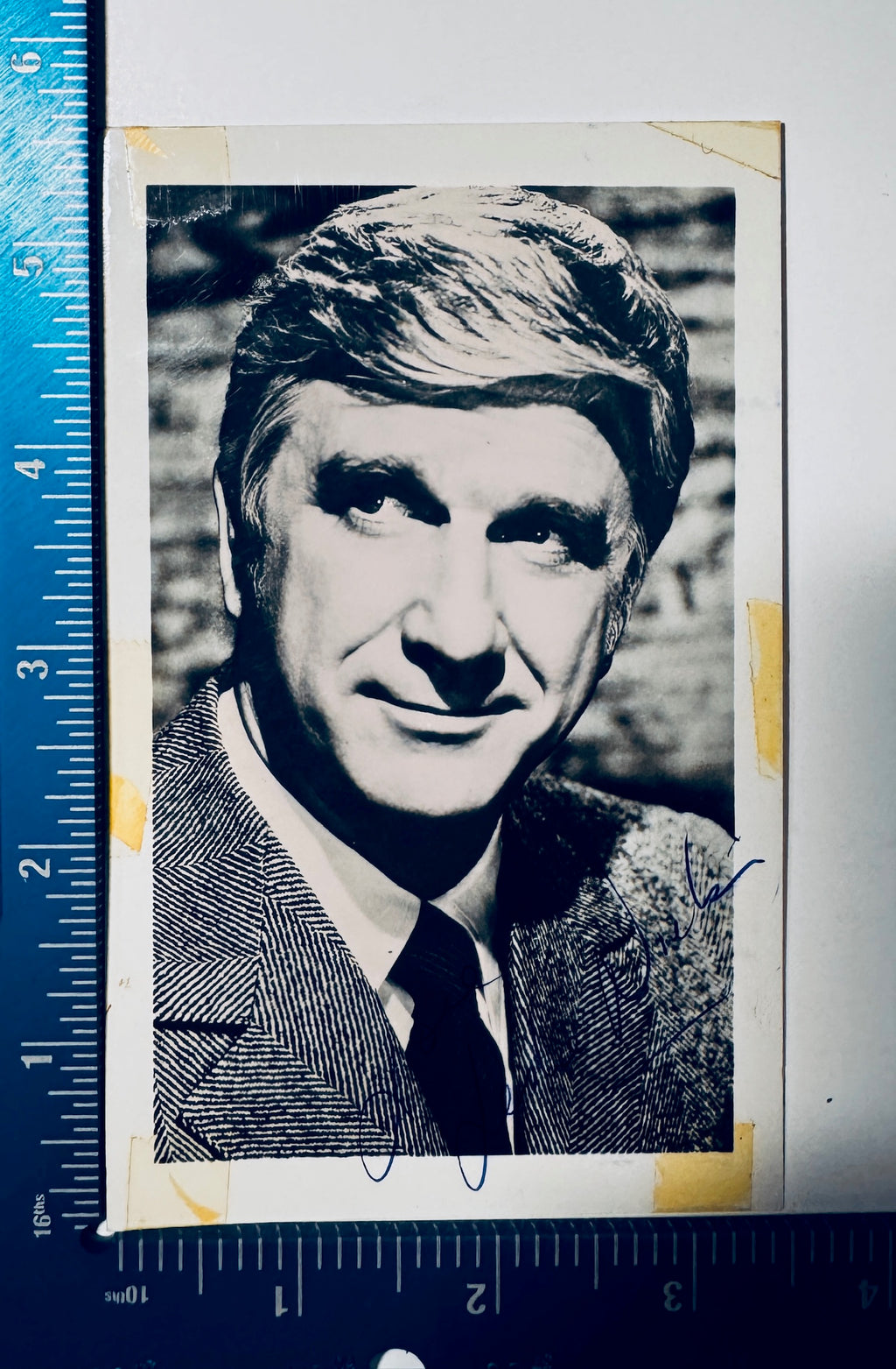 Leslie Nielsen autographed vintage photograph measured with precision ruler showing dimensions approx 3.5x5.5 inches.