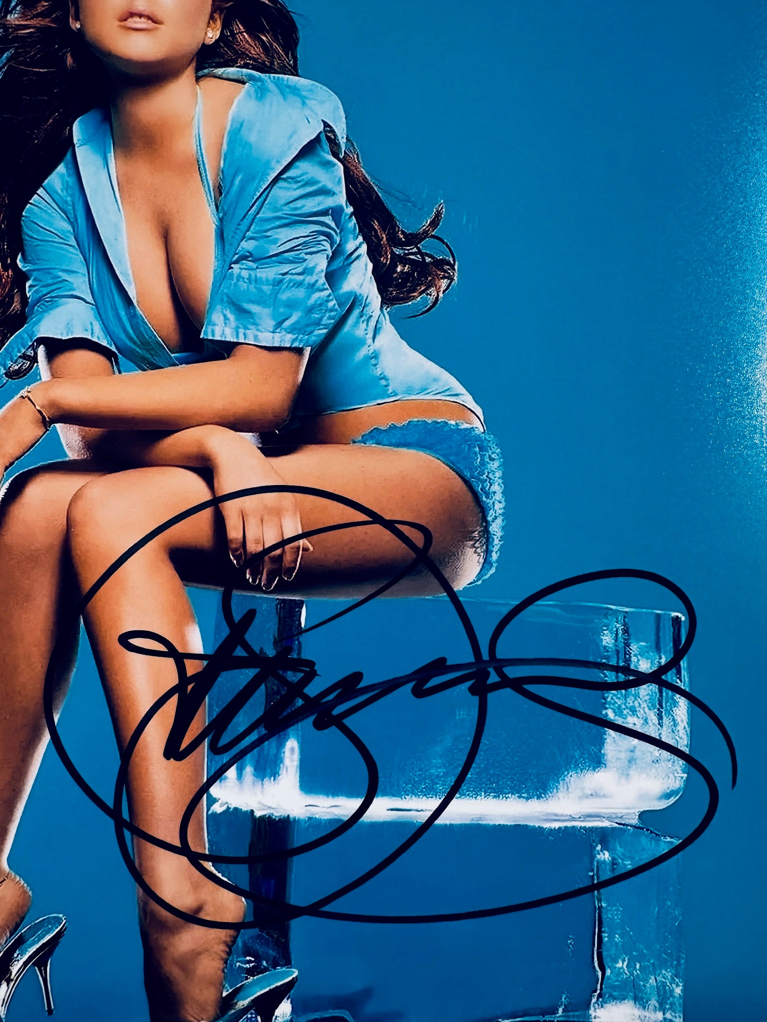 Close-up view of Lindsay Lohan's signature in black marker across the vibrant blue promotional photo.