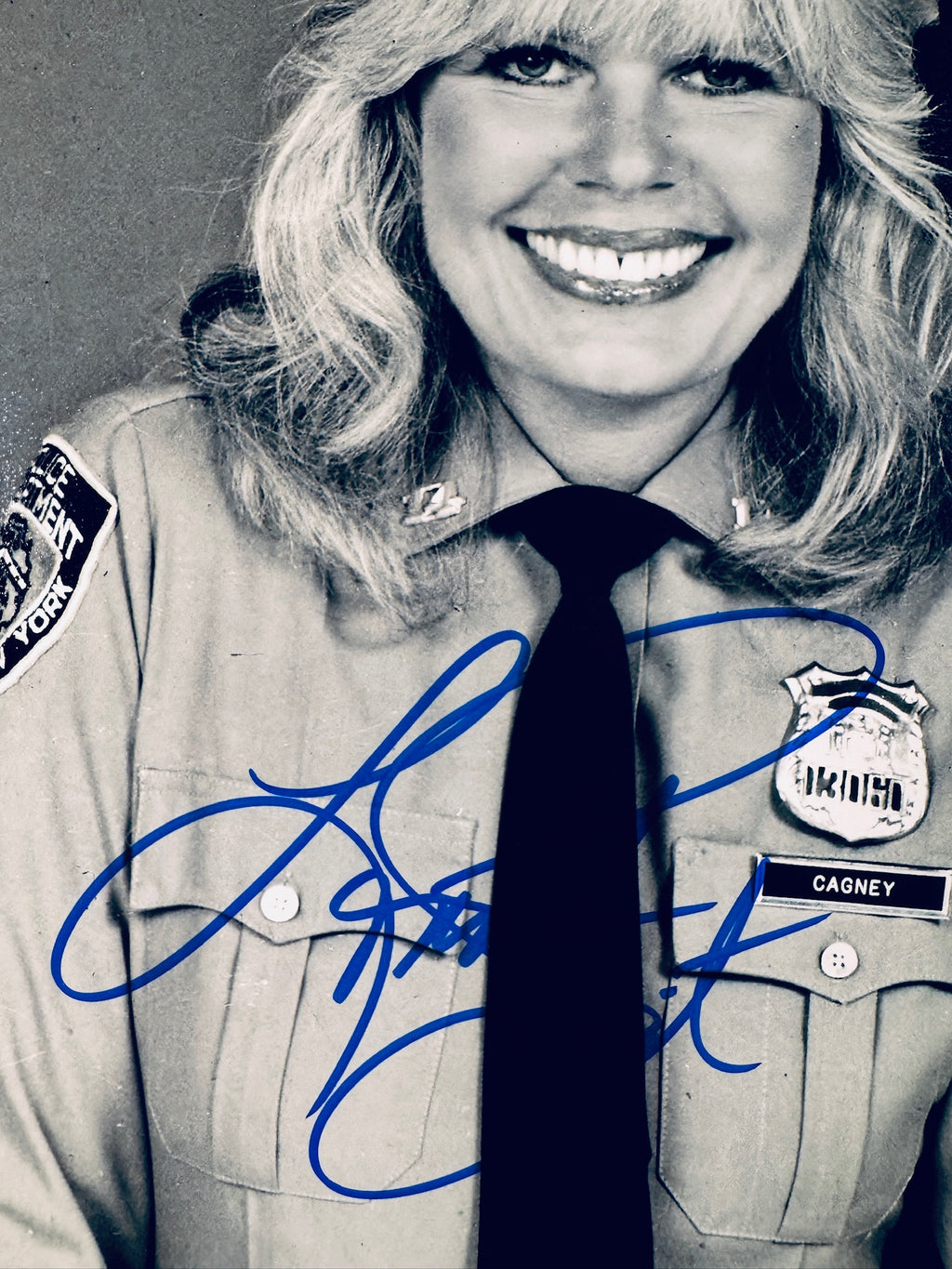 Close-up view of Loretta Swit's signature in blue marker on the Cagney & Lacey promotional matte photo.