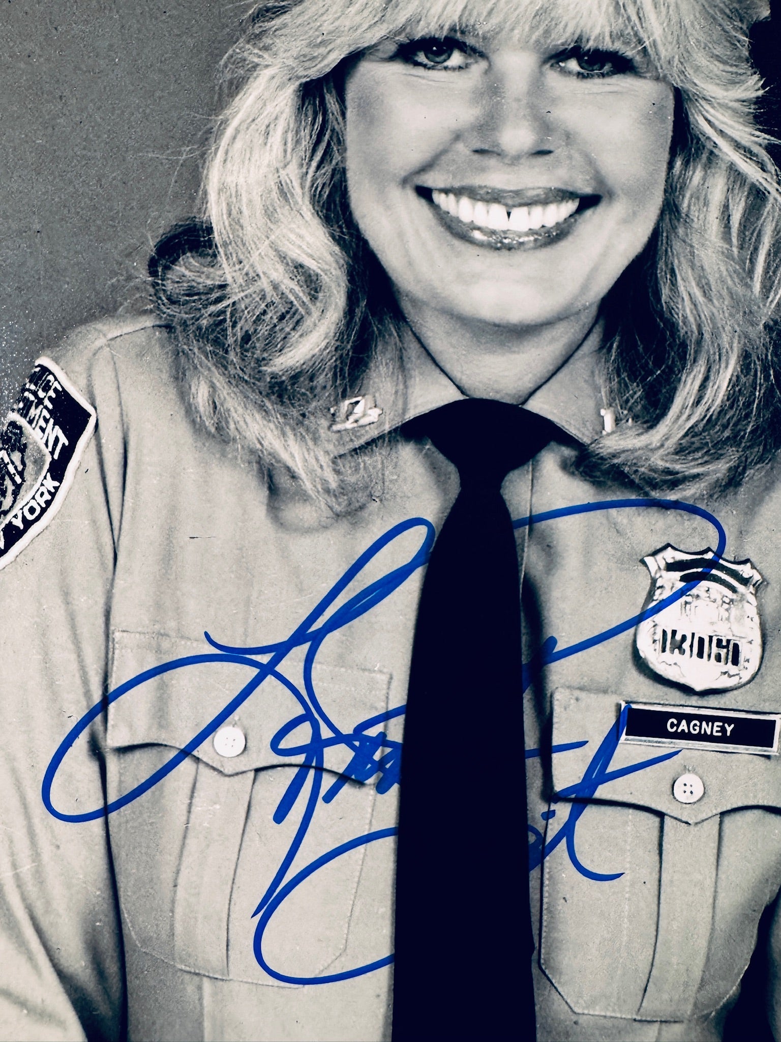 Close-up view of Loretta Swit's signature in blue marker on the Cagney & Lacey promotional matte photo.