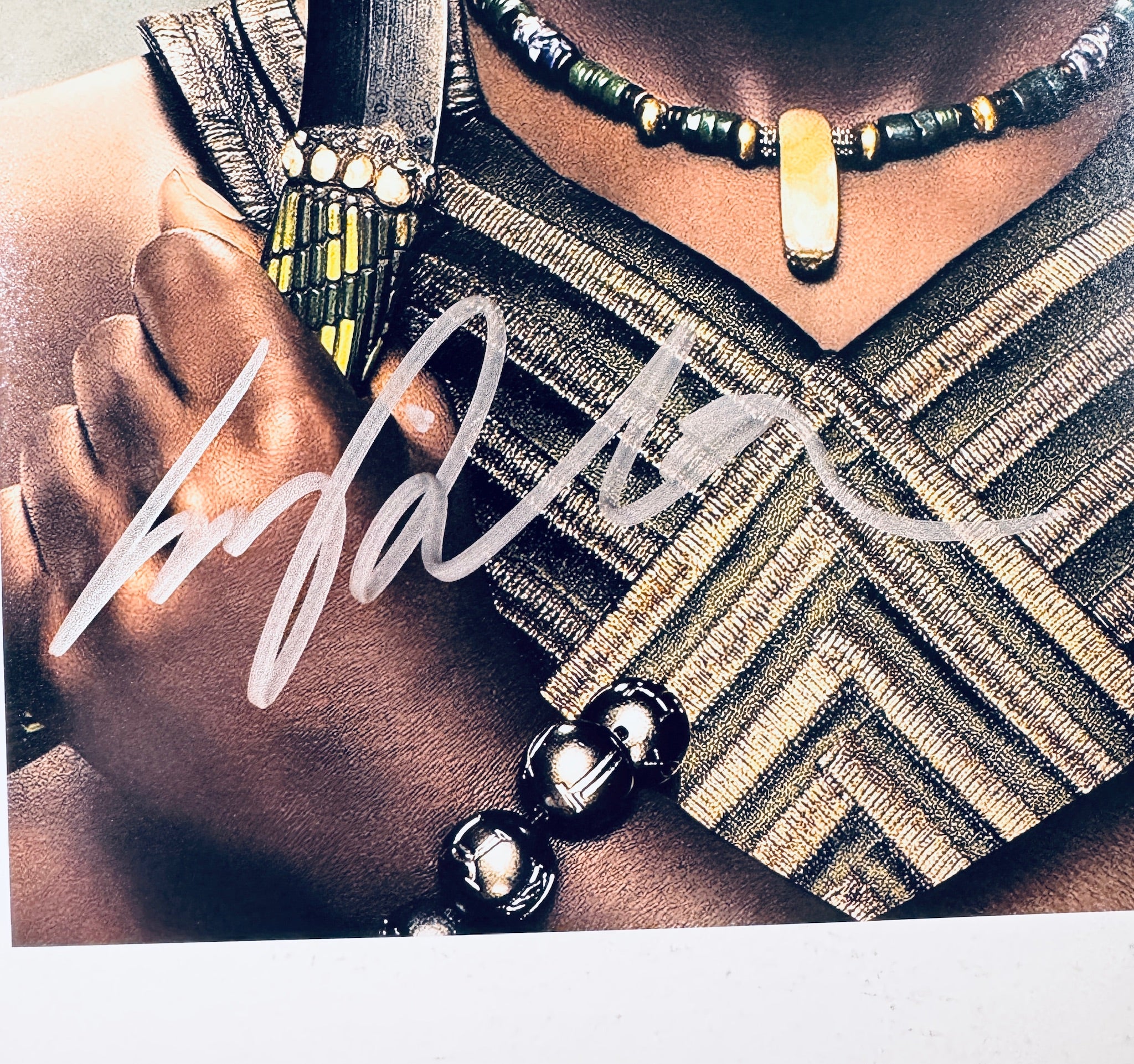 Close-up of Lupita Nyong'o's signature in silver marker on the signed Black Panther 8x10 photo.