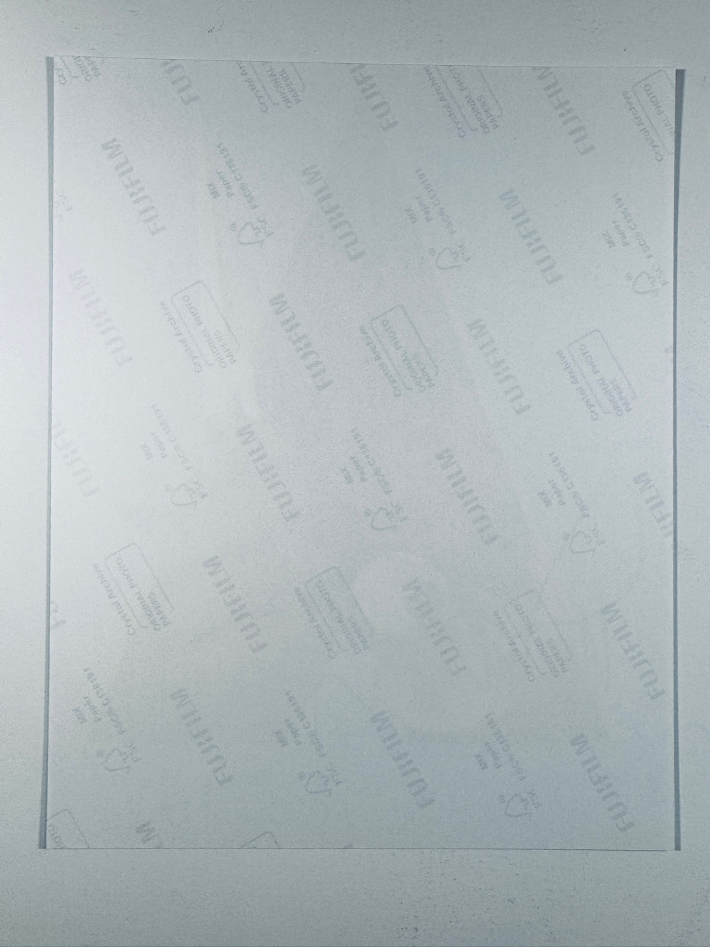 The plain white reverse side of a photographic print showing translucent Fujifilm crystal archive paper watermarks and logos.