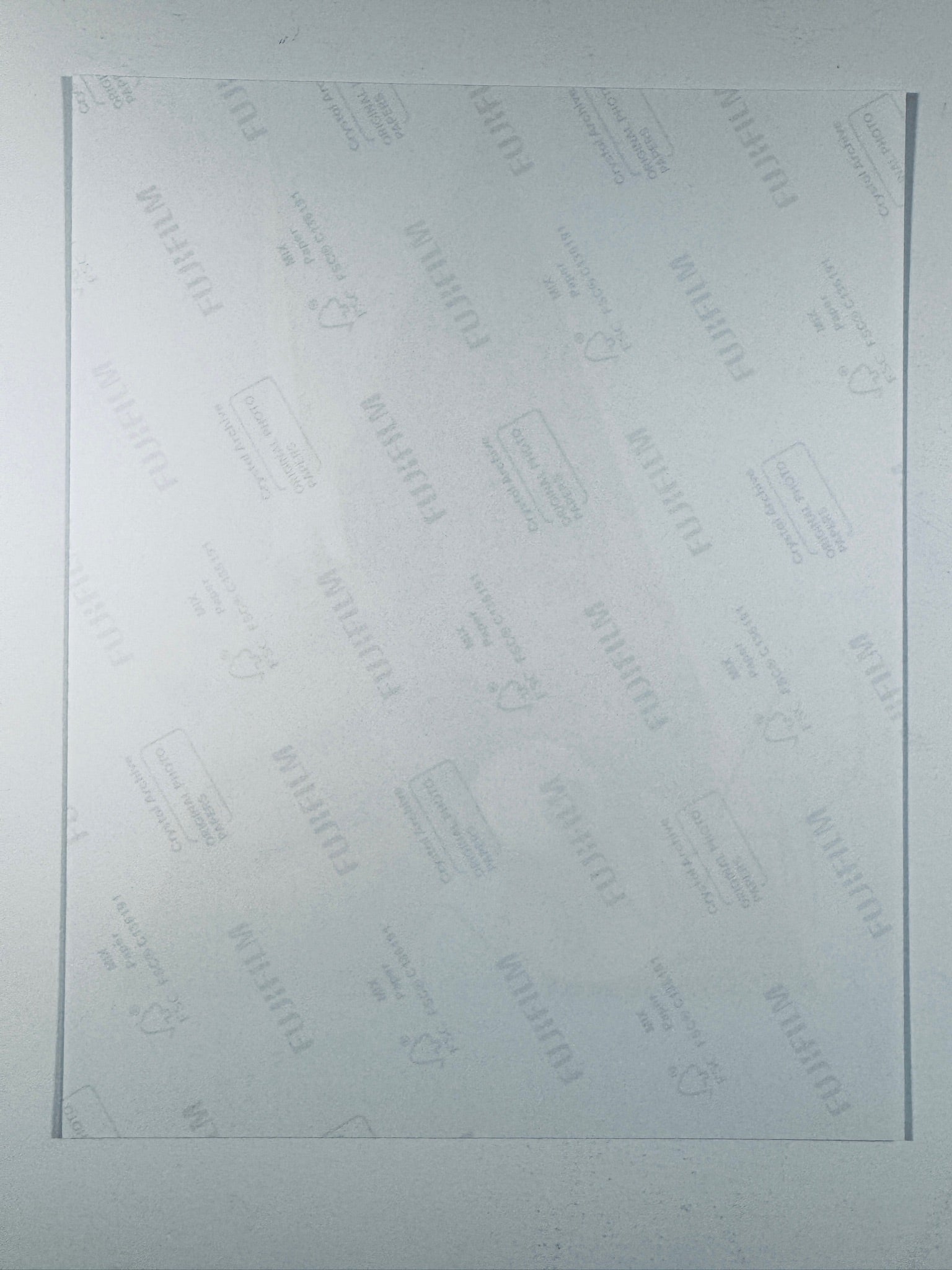 The plain white reverse side of a photographic print showing translucent Fujifilm crystal archive paper watermarks and logos.
