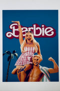 A promotional poster portrait for Barbie featuring Margot Robbie as Barbie in a pink gingham dress sitting atop Ryan Gosling as Ken with a blue background, featuring a blue marker signature across the lower left.