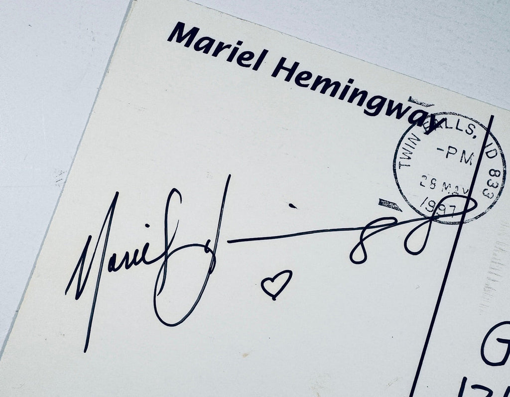 Close-up of Mariel Hemingway's black ink signature alongside a postmark stamp and heart design.