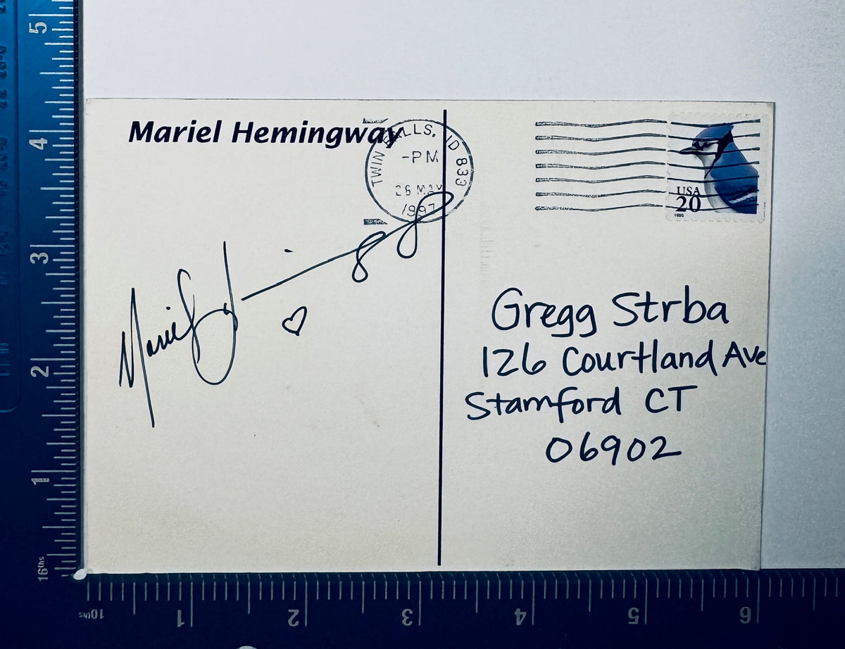 Autographed Mariel Hemingway signed postcard displayed next to a measuring ruler for exact physical dimensions.