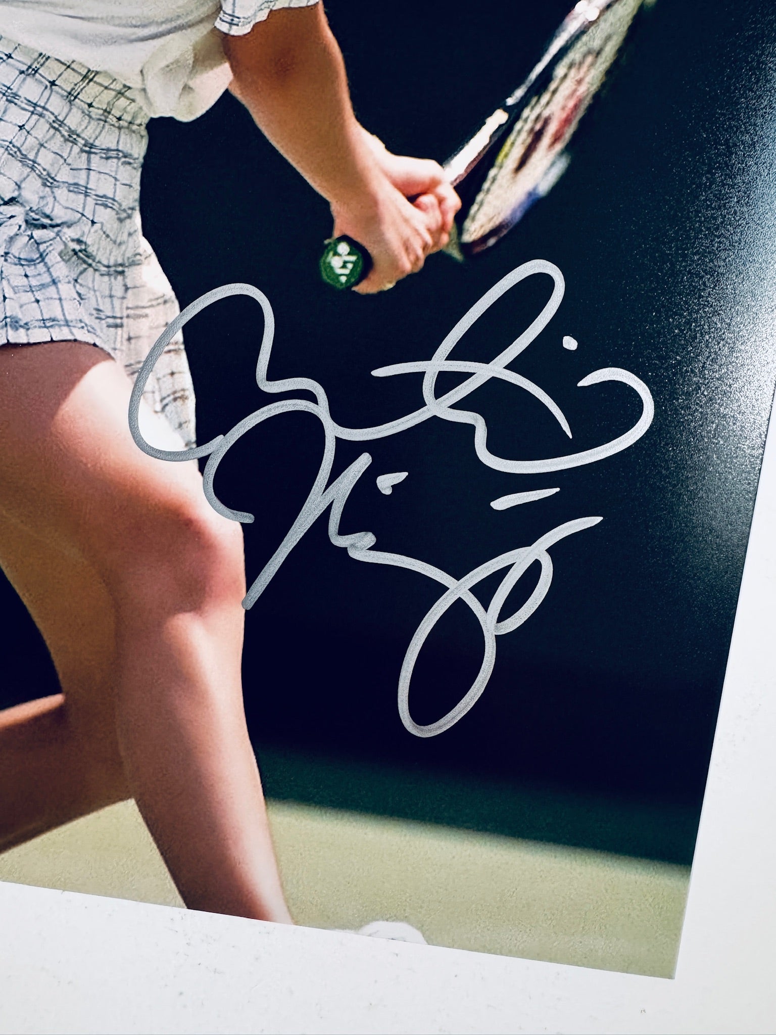 Close-up view of Martina Hingis's silver signature across the lower portion of the tennis action photograph.