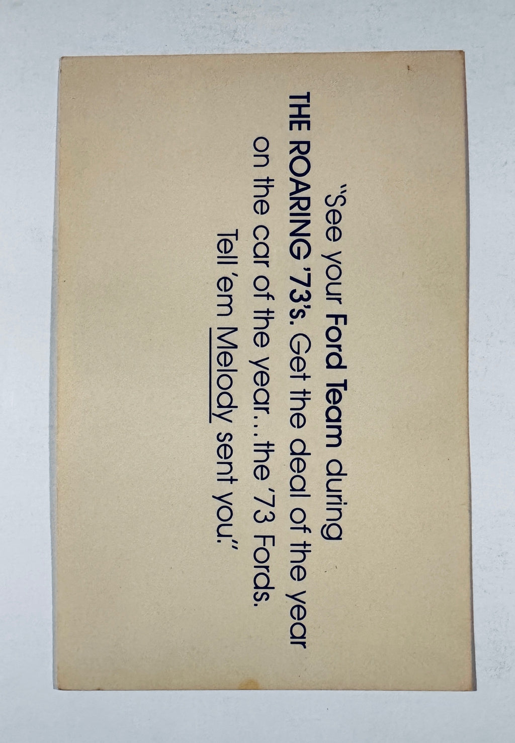 Back side of vintage card showing printed 1973 Ford promotional advertisement text referencing Melody.