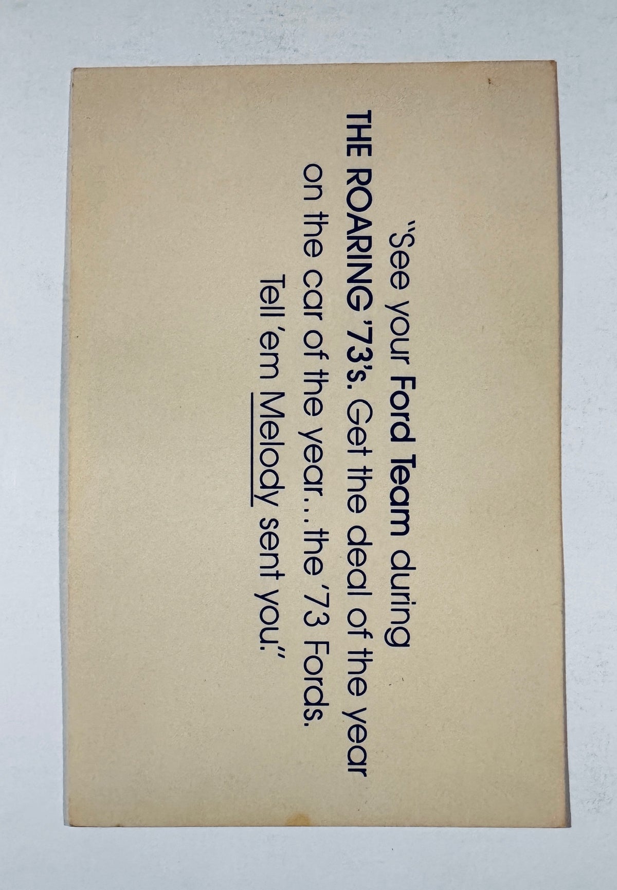 Back side of vintage card showing printed 1973 Ford promotional advertisement text referencing Melody.