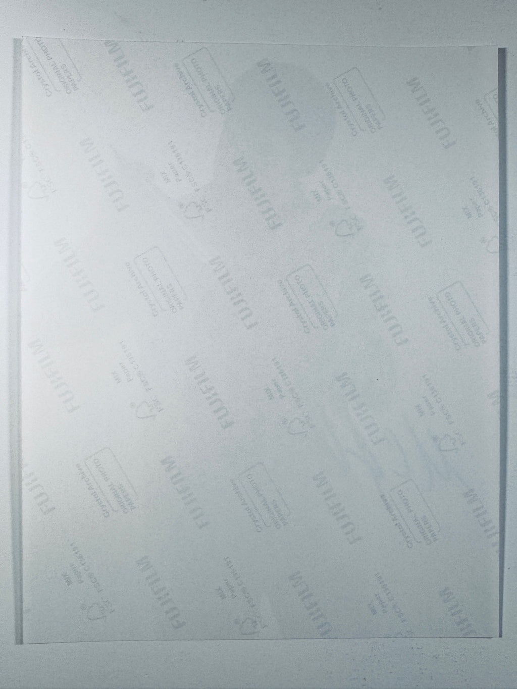 The plain white reverse side of a photographic print showing translucent Fujifilm crystal archive paper watermarks and logos.