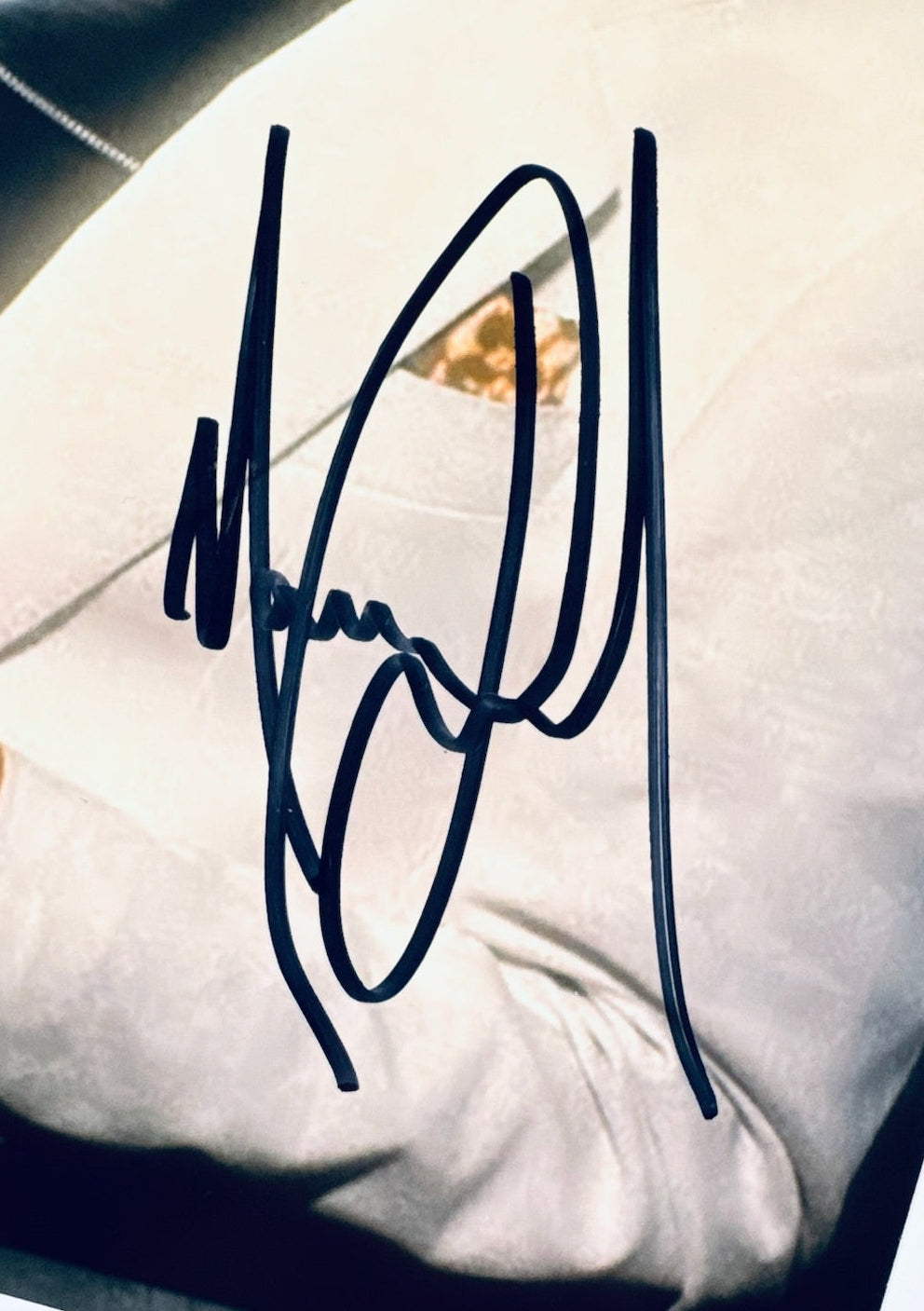 A close-up view showing the authentic hand-signed signature of Michael Jackson on a photograph.