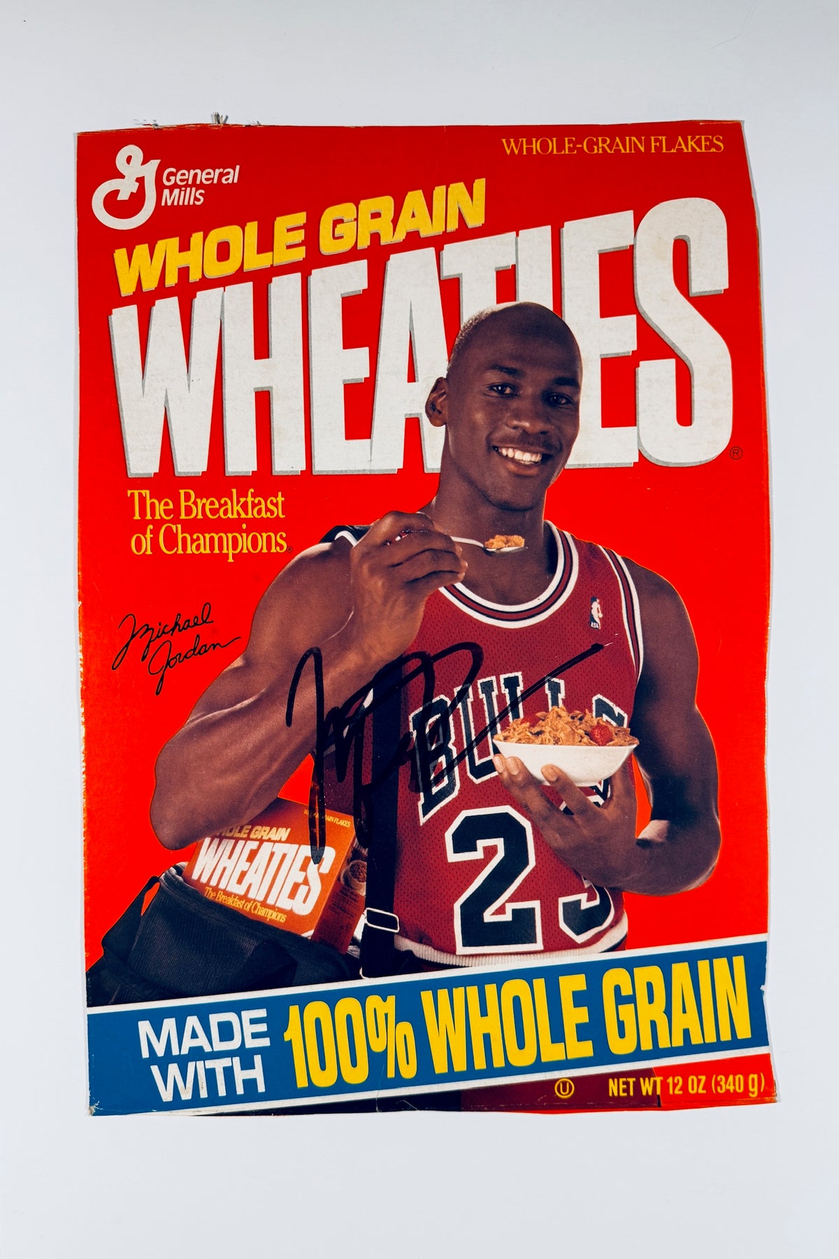 Michael Jordan signed Wheaties cereal box panel featuring him in a red Chicago Bulls number 23 jersey with a black autograph across the front.