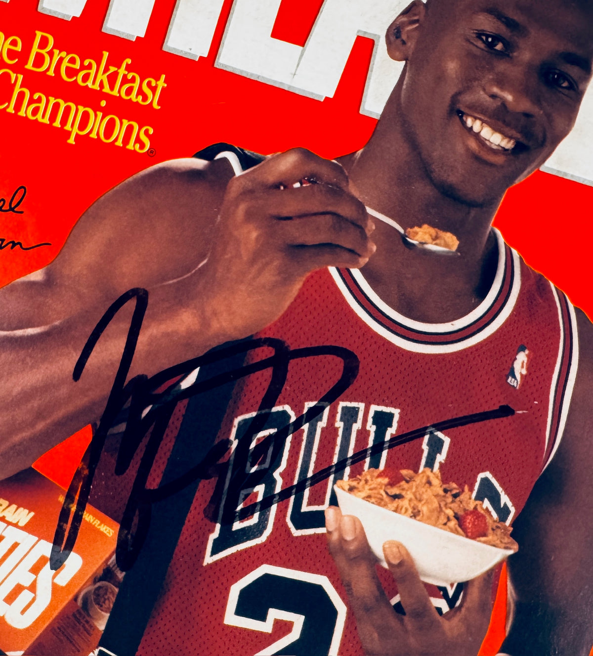 Close-up of Michael Jordan’s black autograph across his red Chicago Bulls jersey on the signed Wheaties cereal box panel.