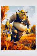 An autographed photo print of Shrek in his running pose from 'The Fairly OddParents', featuring a blue ink signature on the left side. The character is depicted in an outdoor autumn landscape with orange foliage under a blue sky.