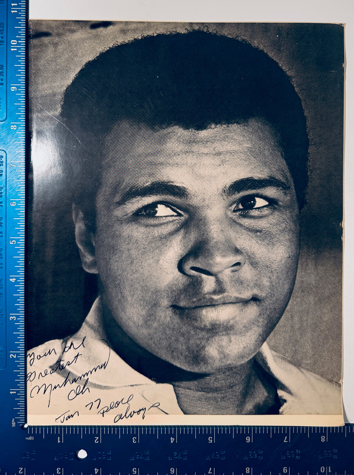 Vintage 8x10 Muhammad Ali autographed photo shown next to a blue ruler measuring 8 by 11 inches.