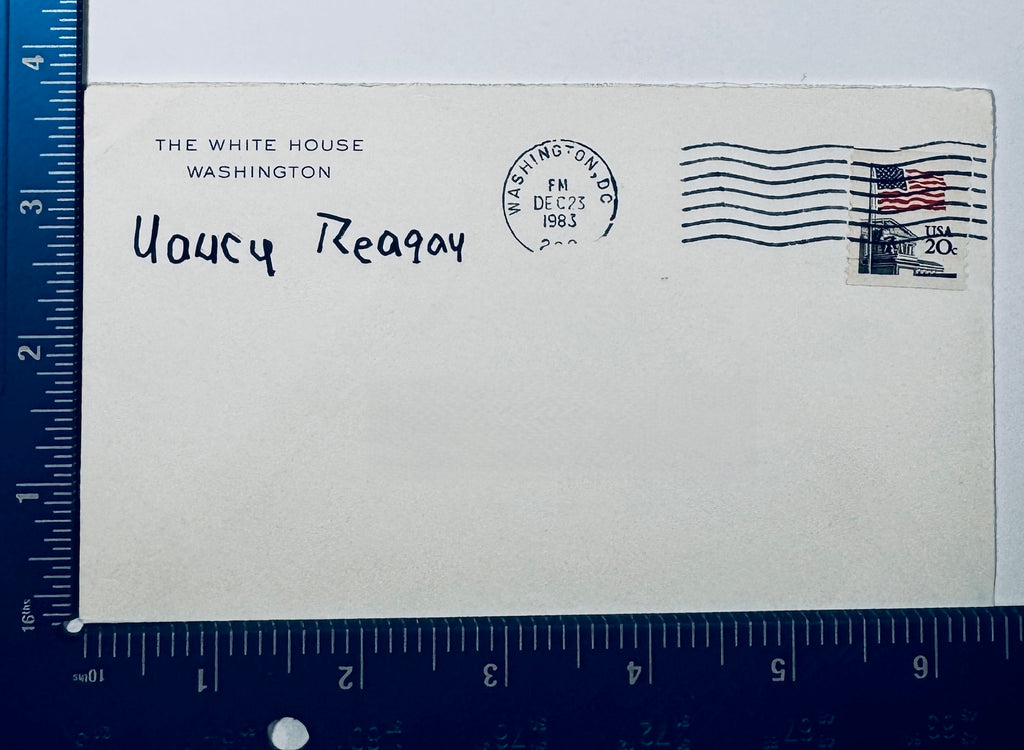 Autographed Nancy Reagan White House postmarked envelope from 1983 positioned next to an L-shaped ruler for size dimensions.