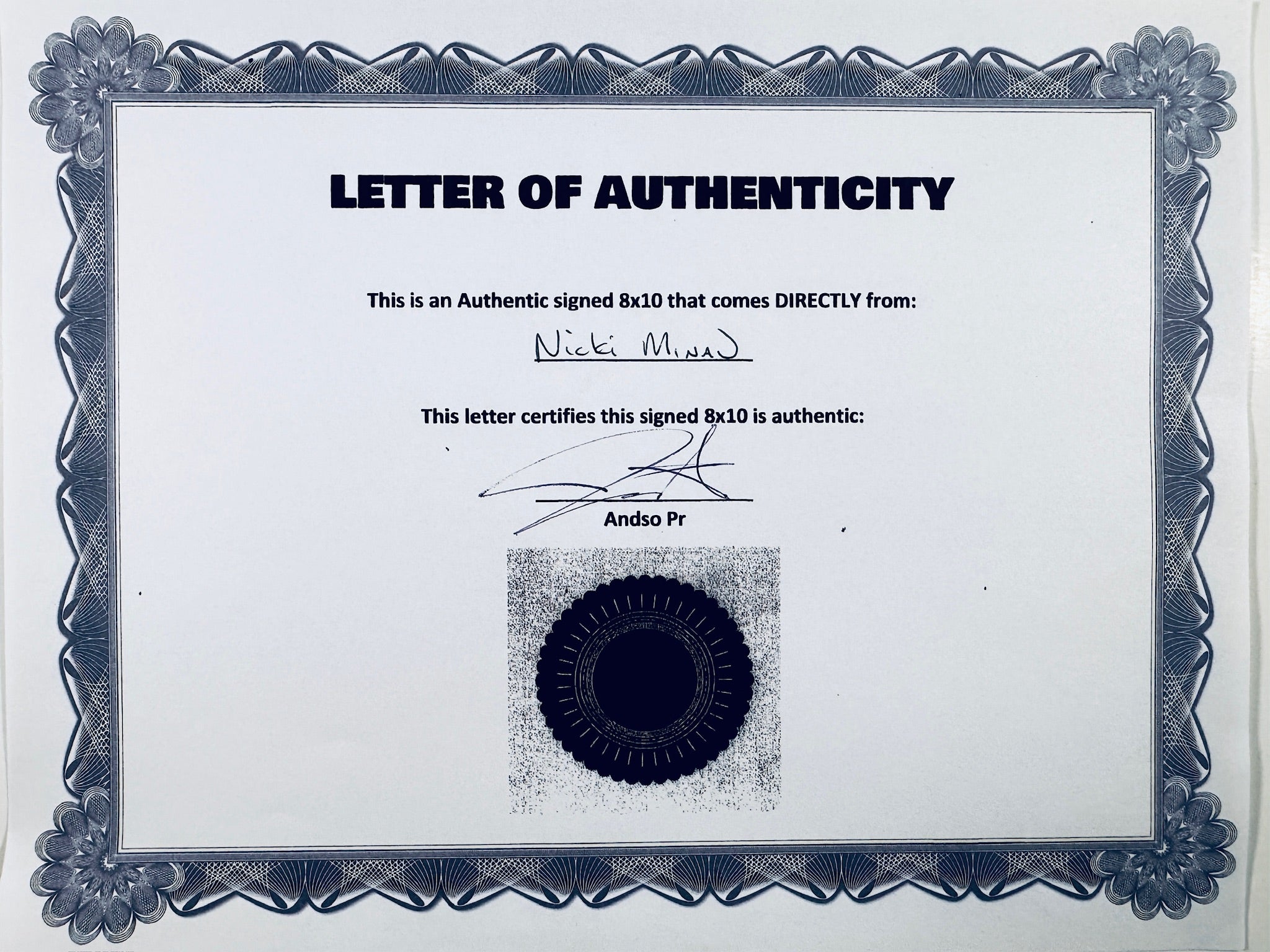 A Letter of Authenticity with a decorative blue-patterned border, certifying an authentic signed 8x10 coming directly from Nicki Minaj, featuring a dark circular seal graphic at the bottom.