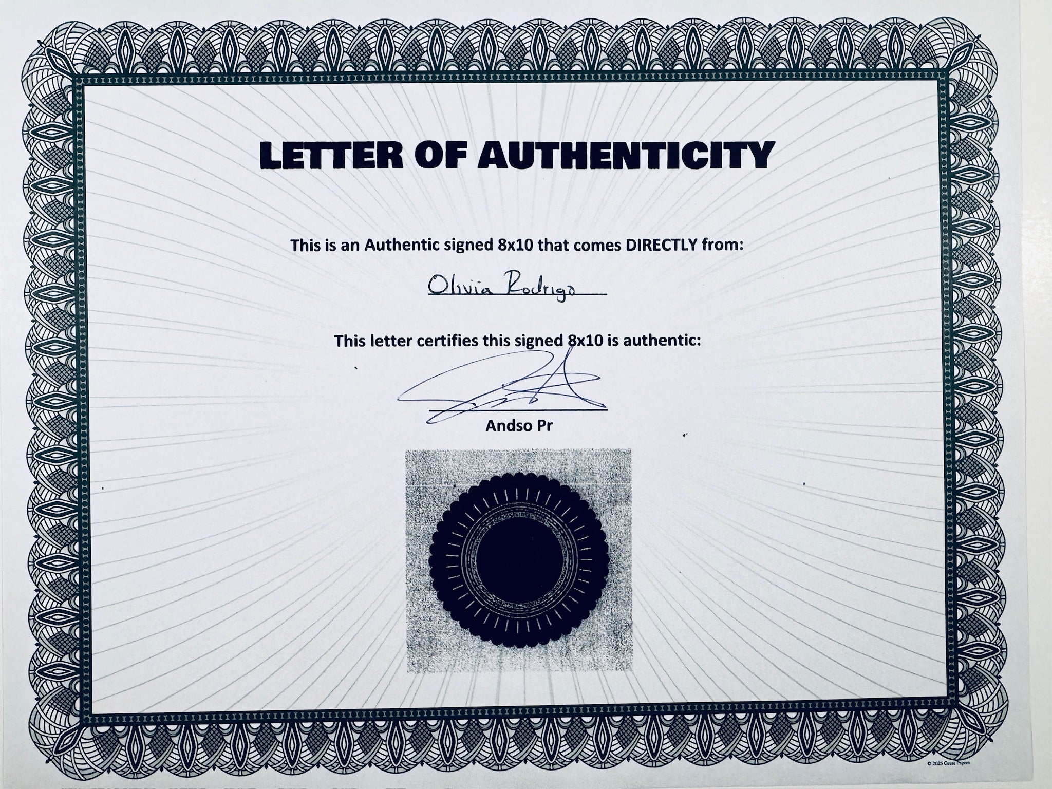 A Letter of Authenticity with a decorative blue-patterned border, certifying an authentic signed 8x10 coming directly from Olivia Rodrigo, featuring a dark circular seal graphic at the bottom.