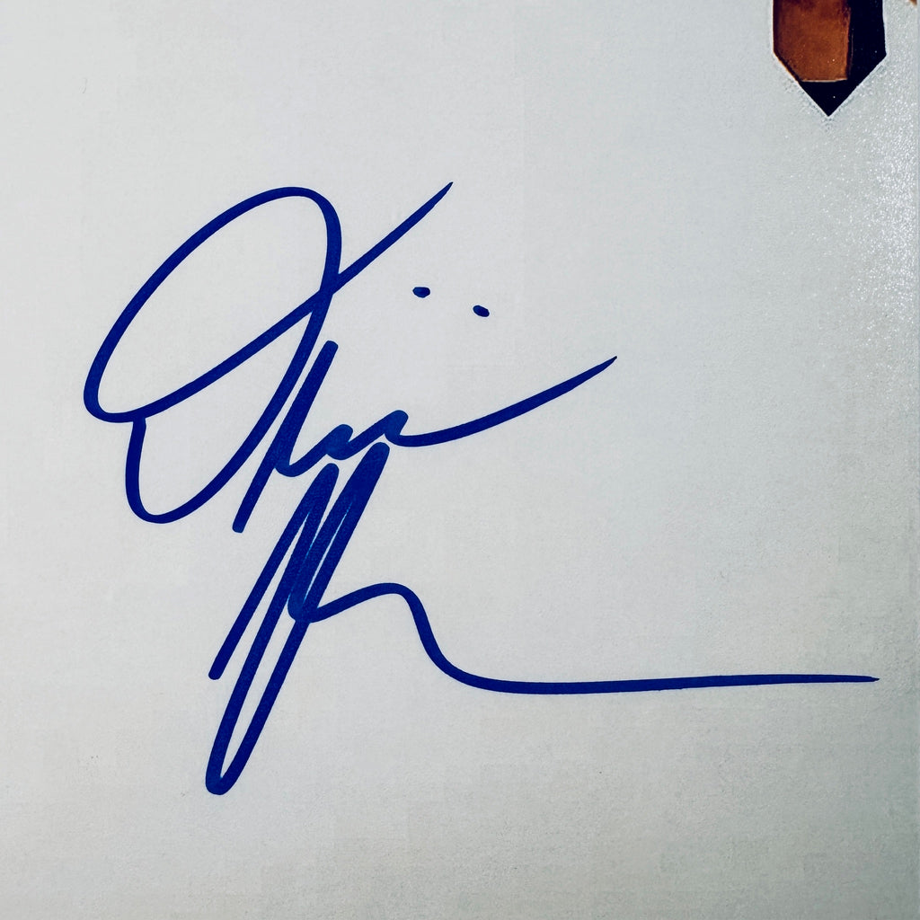 Close-up of Olivia Rodrigo's signature in blue marker on the 8x10 photo.