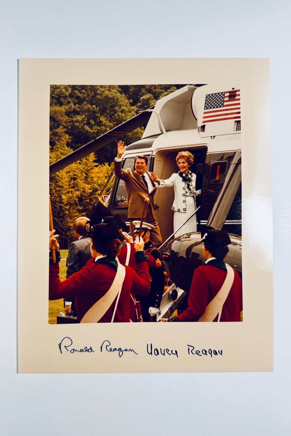 Color photo of President Ronald Reagan and First Lady Nancy Reagan waving from a helicopter with signatures on the border.