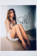 Signed full photo of Paris Jackson sitting on the floor leaning against a wall, featuring a black autograph.