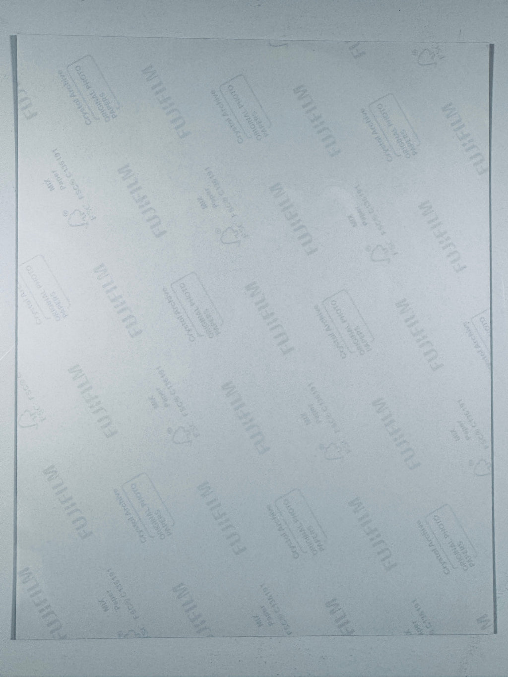 The plain white reverse side of a photographic print showing translucent Fujifilm crystal archive paper watermarks and logos.