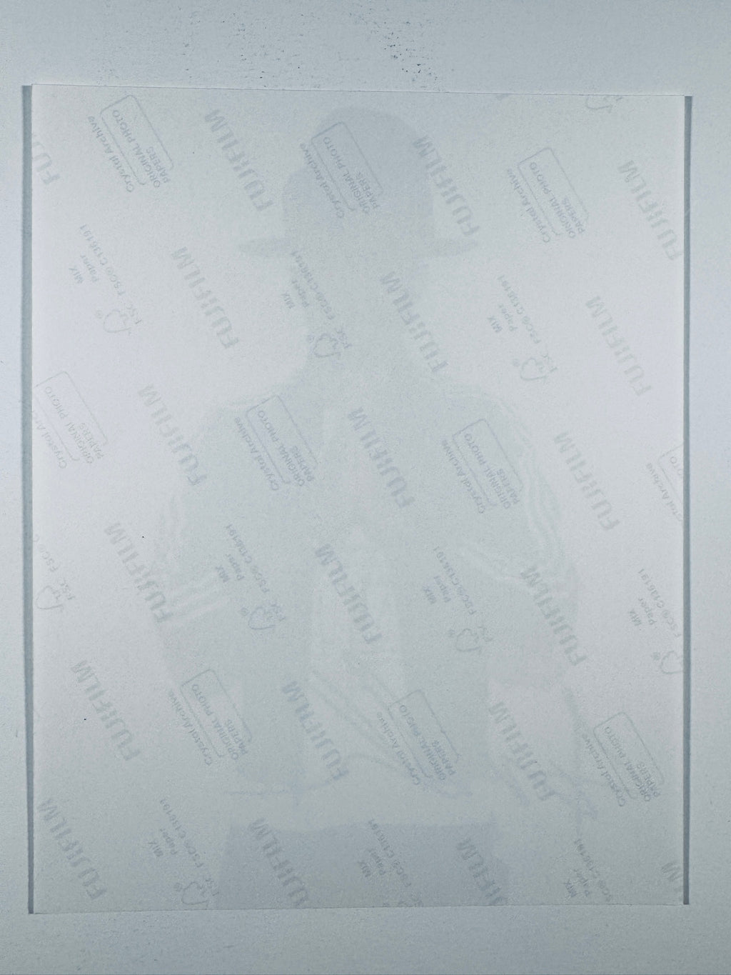 The plain white reverse side of a photographic print showing translucent Fujifilm crystal archive paper watermarks and logos.