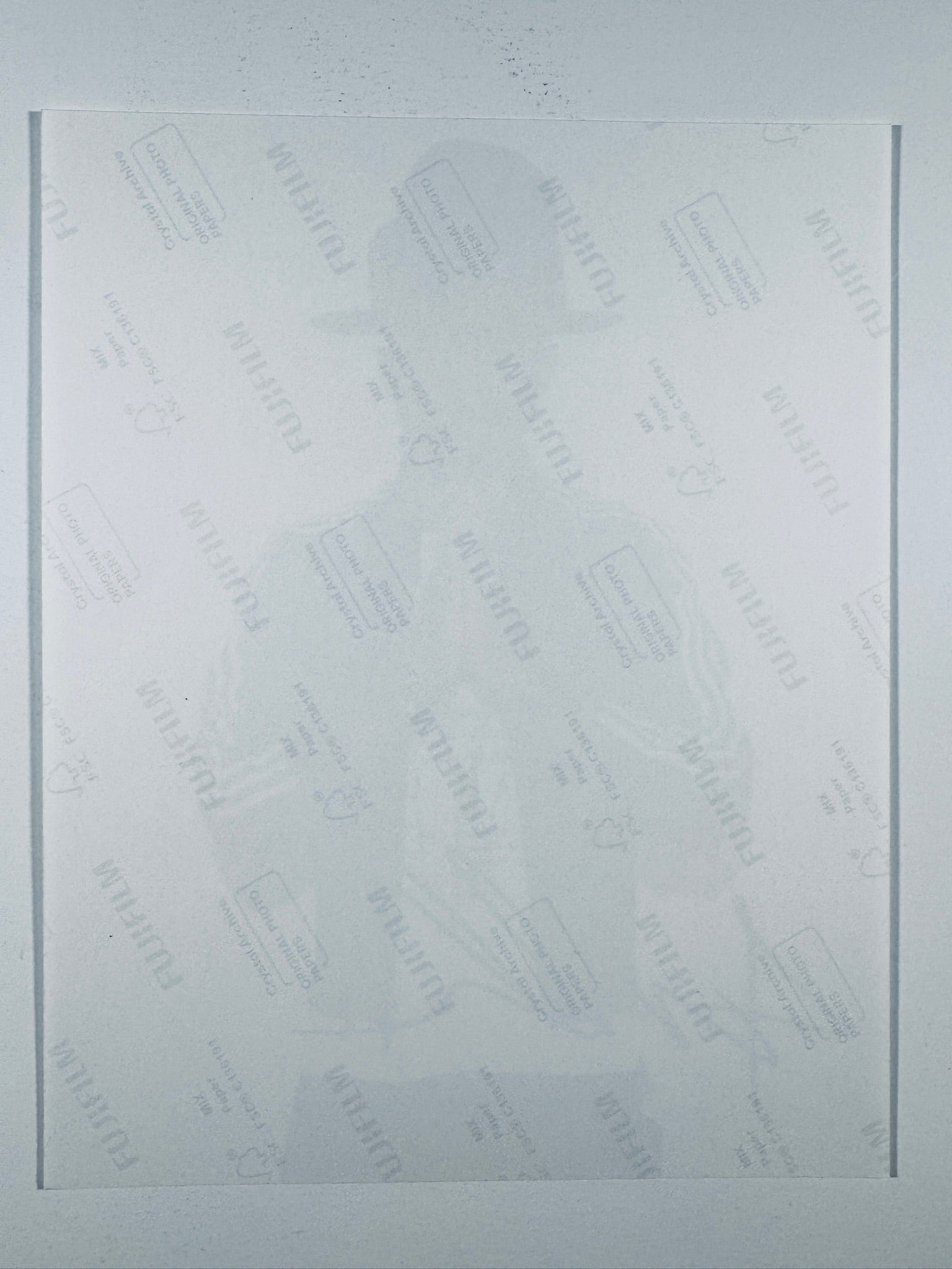 The plain white reverse side of a photographic print showing translucent Fujifilm crystal archive paper watermarks and logos.