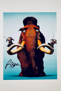 A promotional portrait from Ice Age featuring Manny the woolly mammoth with two possums perched on his tusks against a light blue background, featuring a black marker signature across the lower left.