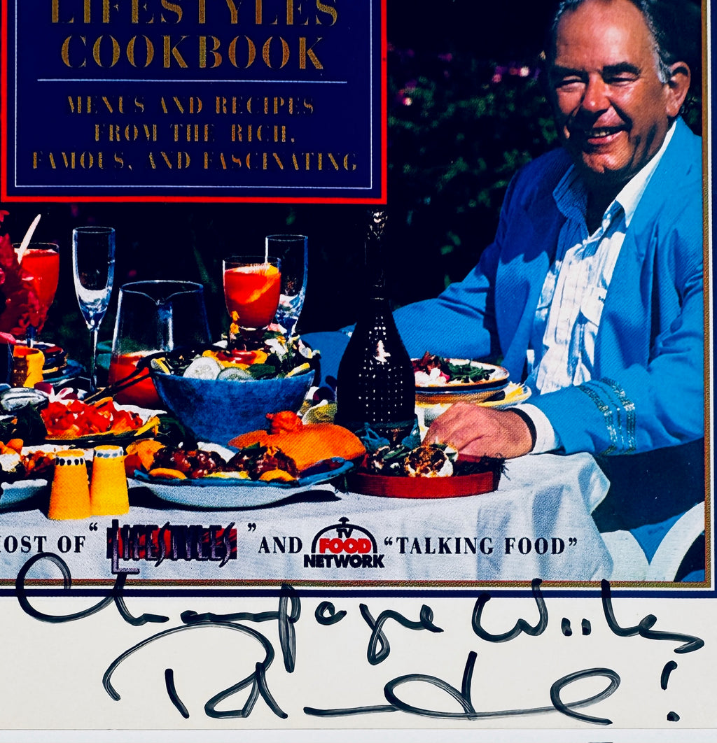 Macro close-up detail of Robin Leach signature and Champagne Wishes catchphrase inscription in black marker.